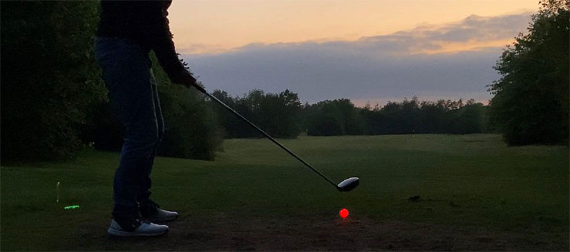 Nachtgolfen leuchtender Golfball auf Tee